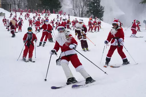 Skiers dressed in Santa Claus outfits hit the slopes for charity at the Sunday River Ski Resort, Sunday, Dec. 11, 2022, in Newry, Maine. (AP Photo/Robert F. Bukaty)
