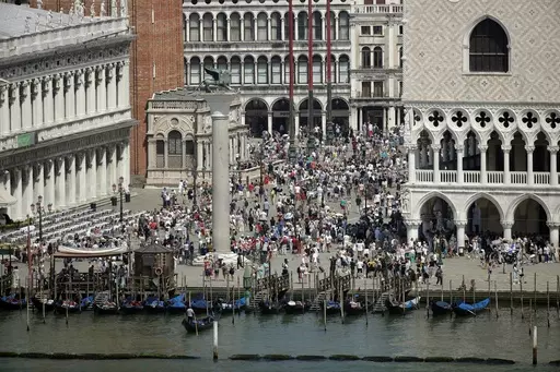 A view of the St. Mark's Square in Venice, Italy, taken on June 8, 2019. Venice authorities have rolled out a pilot program to charge day-trippers 5 euros ($5.45) apiece to enter the fragile lagoon city on peak weekends next year. The aim is to reduce crowds, encourage longer visits and improve the quality of life for residents. (AP Photo/Luca Bruno, File)