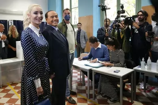  Silvio Berlusconi, leader of center-right, populist Forza Italia is flanked by his partner Marta Fascina, after casting his ballot at a polling station in Milan, Italy, Sunday, Sept. 25, 2022, in Milan, Italy.  Just in time to celebrate his 86th birthday, Italy’s former premier Silvio Berlusconi is making his return to Italy's parliament, winning a seat in the Senate nearly a decade after being banned from public office over a tax fraud conviction. (AP Photo/Antonio Calanni, File)