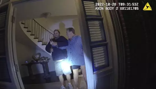 In this image taken from San Francisco Police Department body-camera video, the husband of former U.S. House Speaker Nancy Pelosi, Paul Pelosi, right, fights for control of a hammer with his assailant David DePape during a brutal attack in the couple's San Francisco home on Oct. 28, 2022. Opening statements are scheduled for Thursday, Nov. 8, 2023, in the federal trial of the man accused of breaking into former House Speaker Nancy Pelosi's San Francisco home seeking to kidnap her and bludgeoning