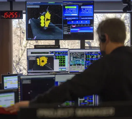 Engineering teams at NASA's James Webb Space Telescope Mission Operations Center at the Space Telescope Science Institute in Baltimore monitor progress as the observatory's second primary mirror wing rotates into position, Saturday, Jan. 8, 2022. The last portion of the 21-foot (6.5-meter) mirror swung into place at flight controllers’ command, completing the unfolding of the James Webb Space Telescope _ the riskiest part of the mission. (Bill Ingalls/NASA via AP)