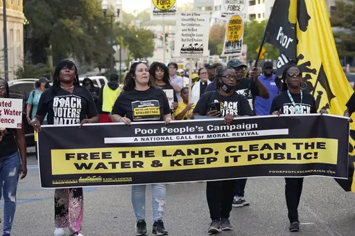 Jackson residents and supporters hold signs as they march to the Governor's Mansion in Jackson, Miss., to protest the ongoing water issues, poverty and other social ills, in the city, Oct. 10, 2022. A federal judge on Thursday, June 29, 2023, temporarily blocked a new Mississippi law that requires people to get permission from state police before having protests or other gatherings near state government buildings in Jackson. (AP Photo/Rogelio V. Solis, File)