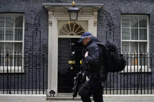 A police officer walks past 10 Downing Street in London, Tuesday, Jan. 25, 2022. London police say they are now investigating Downing Street parties during lockdown. Metropolitan Police Commissioner Cressida Dick revealed an investigation was underway in a statement before the London Assembly on Tuesday. Dick said Scotland Yard is now investigating "a number of events" at Downing Street. (AP Photo/Kirsty Wigglesworth)