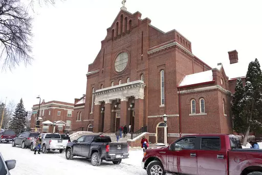 Church of the Incarnation is shown, Sunday, Jan. 23, 2022, in Minneapolis, where residents could pick up coats, sweaters and frozen chicken. With attendance dwindling, historic urban churches built in the early to mid-20th century, are fulfilling their faith-based mission to serve their neighbors. Between mass, people can pick up coats and sweaters along with bags of frozen chicken. (AP Photo/Jim Mone)