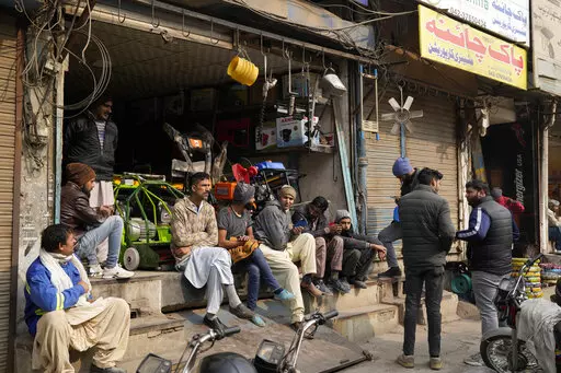 Shopkeepers and workers wait for electric power at a market following a power breakdown across the country, in Lahore, Pakistan, Monday, Jan. 23, 2023. Much of Pakistan was left without power for several hours on Monday morning as an energy-saving measure by the government backfired. The outage spread panic and raised questions about the cash-strapped government’s handling of the crisis. (AP Photo/K.M. Chaudary)