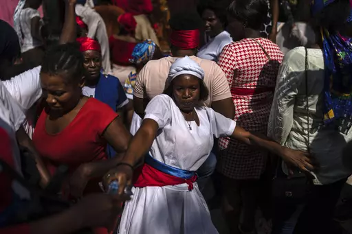 A Vodouist clad in white invokes a gede spirit during the Saint George celebration, in Port-au-Prince, Haiti, April 24, 2024. Shunned publicly by politicians and intellectuals for centuries, Vodou is transforming into a more powerful and accepted religion across Haiti, where its believers were once persecuted. (AP Photo/Ramon Espinosa, File)