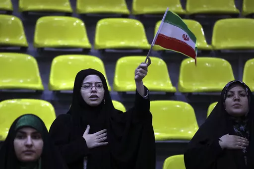 Iranian women listen to their country's national anthem as one of them waves the national flag during an election campaign rally ahead of the March 1, parliamentary and Assembly of Experts elections, in Tehran, Iran, Tuesday, Feb. 27, 2024. Iran is holding parliamentary elections this Friday, yet the real question may not be who gets elected but how many people actually turn out to vote. Separately, Iranians will also vote on Friday for members of the country's 88-seat Assembly of Experts, an ei