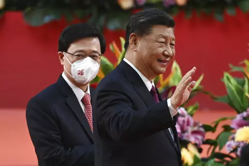 Hong Kong's new Chief Executive John Lee, left, walks with China's President Xi Jinping following Xi's speech after a ceremony to inaugurate the city's new leader and government in Hong Kong Friday, July 1, 2022, on the 25th anniversary of the city's handover from Britain to China. (Selim Chtayti/Pool Photo via AP)