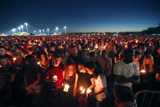People attend a candlelight vigil for the victims of the Wednesday shooting at Marjory Stoneman Douglas High School, in Parkland, Fla., Thursday, Feb. 15, 2018. After a gunman murdered 14 students and three staff members at Parkland’s Marjory Stoneman Douglas High School, their families were left with a burning question: How do we go on with our lives while honoring our loved one’s memory? (AP Photo/Gerald Herbert, File)