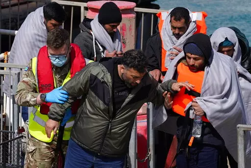 A group of people thought to be migrants are brought in to Dover, Kent, by the RNLI, following a small boat incident in the Channel, Thursday April 14, 2022. Britain's Conservative government has struck a deal with Rwanda to send some asylum-seekers thousands of miles away to the East African country, a move that opposition politicians and refugee groups condemned as inhumane, unworkable and a waste of public money. (Gareth Fuller/PA via AP)