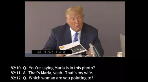 In this image taken from video released by Kaplan Hecker & Fink, former President Donald holds a photograph, presented as evidence during his Oct. 19, 2022 deposition, that shows E. Jean Carroll and her then-husband John Johnson meeting Trump and his wife Ivanka at an event in the 1980s. In his deposition, Trump mistook Carroll as Marla Maples, his now ex-wife, when shown the image. The video recording of Trump being questioned about the rape allegations against him was made public for the first