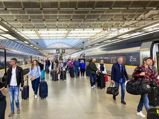 Travelers at St. Pancras International train station board the high speed Eurostar train to Paris, in London, Saturday, May 21, 2022. The World Economic Forum is encouraging European attendees to come to its exclusive gathering in the Swiss Alps by train. Its part of efforts to burnish the sustainability credentials for an event in Davos that conjures up up images of government leaders, billionaire elites and corporate titans jetting in on carbon-spewing private planes. (AP Photo/Kelvin Chan)