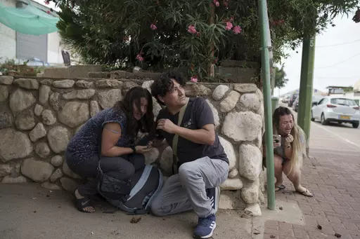 Israelis take cover from the incoming rocket fire from the Gaza Strip in Ashkelon, southern Israel on Oct. 11, 2023. (AP Photo/Leo Correa, File)