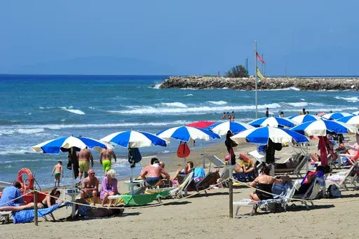 People enjoy a sunny day at an establishment on the beach in Tuscany's Castiglione della Pescaia, Italy, Sunday, May 24, 2020. (Jennifer Lorenzini/LaPresse via AP)
