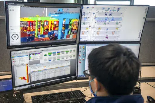 A worker uses a computer terminal to monitor remote operations at a container port in Tianjin, China, on Jan. 16, 2023. As technicians in a distant control room watch on display screens, an automated crane at one of China's busiest ports moves cargo containers from a Japanese freighter to self-driving trucks in a scene Chinese tech giant Huawei sees as its future after American sanctions crushed its smartphone brand. (AP Photo/Mark Schiefelbein)