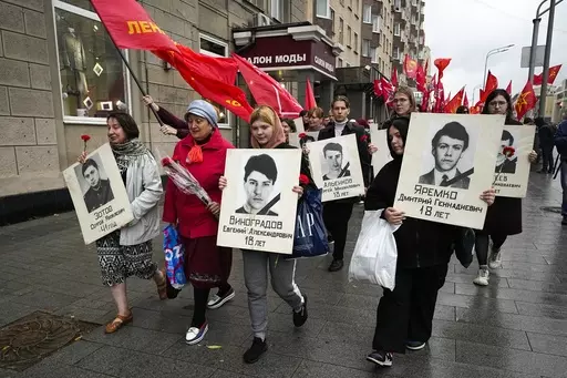 People march with flowers and portraits of those who were killed during the 1993 bloody clashes between government forces and supporters of the rebellious parliament during a rally marking the 30th anniversary of the events in Moscow, Russia, Wednesday, Oct. 4, 2023. The authorities said that 124 people died in the clashes on Oct. 3-4, 1993, but unofficial estimates suggested a higher death toll. (AP Photo/Alexander Zemlianichenko)