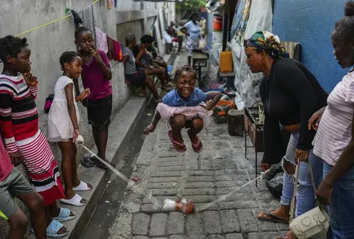 A girl plays a jump rope game at a school housing residents displaced by gang violence in Port-au-Prince, Haiti, May 15, 2024. (AP Photo/Ramon Espinosa)