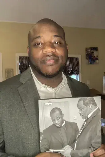 Darrell Dixon holds a photo of him and his dad, Darrell Dixon Sr., at his home in Hernando, Miss., on August 11, 2024. (Millicent Dixon via AP)
