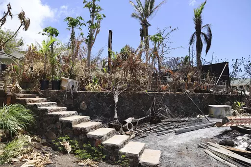 The ruins of a home destroyed by a deadly August wildfire lay outside the boundary of a Hawaiian homestead community in Lahaina, Hawaii, on Friday, Sept. 1, 2023. The Villages of Leiali'I, a Native Hawaiian neighborhood, lost only two out of 104 houses, even though many homes were destroyed in other parts of Lahaina. (AP Photo/Marco Garcia)