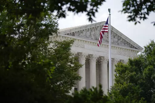 An American flag waves in front of the U.S. Supreme Court building in Washington, June 27, 2022. Supreme Court arguments are continuing long after a red light tells lawyers to stop. Arguments that usually lasted an hour have stretched beyond two this term so on many days it is well past lunchtime before the court breaks. (AP Photo/Patrick Semansky, File)