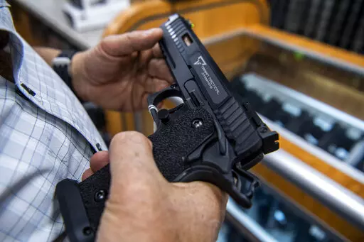 A customer checks out a hand gun that is for sale and on display at SP firearms on June 23, 2022, in Hempstead, New York. A landmark Supreme Court decision on the Second Amendment is dismantling gun law across the country, dividing judges and sowing confusion over what firearm restrictions can remain on the books. Experts say the high court’s ruling that outlined a new test for evaluating gun laws left open many questions, resulting in an increasing number of conflicting decisions as lower cou