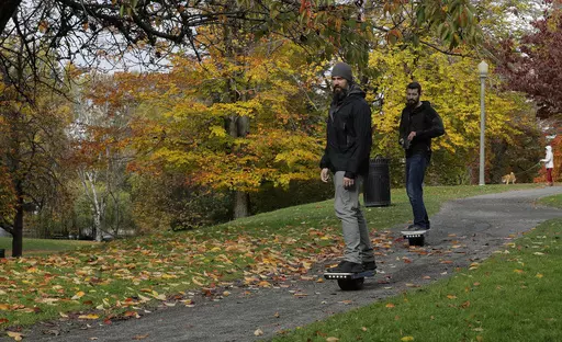 Two people ride Onewheels through Wright Park in Tacoma, Wash., on Oct. 26, 2018. All models of Onewheel self-balancing electric skateboards are under recall after at least four deaths and multiple injuries were reported in recent years, federal regulators said last week.(AP Photo/Ted S. Warren, File)