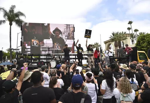 Kal Penn, center left, and John Cho, center right, speak during a rally outside Paramount Pictures Studio on Wednesday, Sept. 13, 2023, in Los Angeles. The film and television industries remain paralyzed by Hollywood's dual actors and screenwriters strikes. (Photo by Richard Shotwell/Invision/AP)