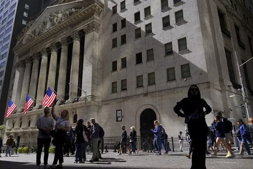 Visitors to the financial district walk past the New York Stock Exchange, Friday, Sept. 23, 2022, in New York. After sweeping through battles in statehouses across the country, the war against what's called ESG investing is heating up in Congress. (AP Photo/Mary Altaffer, File)