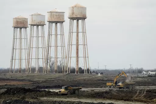 Workers prepare the site of a $4 billion Panasonic EV battery plant Thursday, March 30, 2023, near DeSoto, Kan. Economic incentives offered by Kansas state and local governments beat out those offered by neighboring Oklahoma to help lure the project to the site on land formerly occupied by an Army ammunition plant. (AP Photo/Charlie Riedel)
