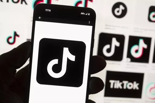 The TikTok logo is displayed on a mobile phone in front of a computer screen, Oct. 14, 2022, in Boston. On Tuesday, May 7, 2024, TikTok and its Chinese parent company ByteDance filed suit against the U.S. federal government to challenge a law that would force the sale of ByteDance's stake or face a ban, saying that the law is unconstitutional. (AP Photo/Michael Dwyer, File)