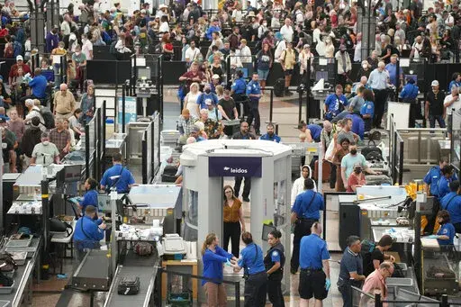 Travelers queue up at the south security checkpoint in Denver International Airport as the Labor Day holiday approaches Tuesday, Aug. 30, 2022, in Denver. (AP Photo/David Zalubowski)