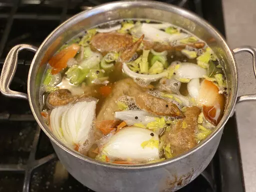 Vegetables and turkey parts cook on a stove to make turkey stock in New Milford, Conn. in November 2022. (Katie Workman via AP)