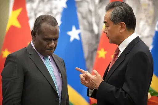 Solomon Islands Foreign Minister Jeremiah Manele, left, and Chinese Foreign Minister Wang Yi talk during a ceremony to mark the establishment of diplomatic relations between the Solomon Islands and China at the Diaoyutai State Guesthouse in Beijing on Sept. 21, 2019. Wang is visiting the South Pacific with a 20-person delegation this week in a display of Beijing's growing military and diplomatic presence in the region. (AP Photo/Mark Schiefelbein, Pool, File)