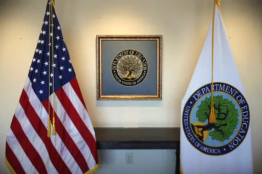 Flags decorate a space outside the office of the education secretary at the Education Department, Aug. 9, 2017, in Washington. College programs that leave graduates underpaid or buried in loans would be cut off from federal money under a proposal issued Wednesday, May 17, 2023, by the Biden administration, but the rules would apply only to for-profit colleges and a tiny fraction of programs at traditional universities. (AP Photo/Jacquelyn Martin, File)