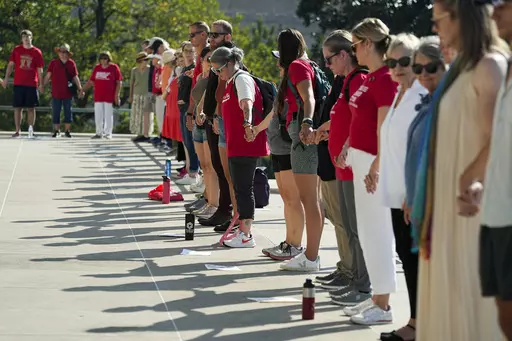 People hold hands around the State Capitol during a prayer session before a special session of the state legislature on public safety Monday, Aug. 21, 2023, in Nashville, Tenn. (AP Photo/George Walker IV)
