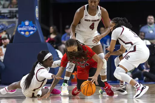 South Carolina's Laeticia Amihere, at left and Zia Cooke (1) go for a loose ball with Mississippi's Madison Scott (24) in the first half of an NCAA college basketball game during the Southeastern Conference women's tournament in Greenville, S.C., Saturday, March 4, 2023. (AP Photo/Mic Smith)