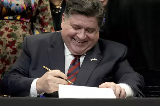 Illinois Gov. J.B. Pritzker signs into law the Paid Leave For All Workers Act on Monday, March 13, 2023, in Chicago. Illinois became one of three U.S. states to require employers to offer paid time off for any reason starting in January of 2024. (AP Photo/Charles Rex Arbogast)