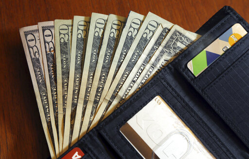 In this June 15, 2018, file photo, cash is fanned out from a wallet in North Andover, Mass. Spend enough time in the personal finance corners of social media and you’re bound to come across someone talking about how much passive income they make — and it’s likely they make it sound pretty easy.  (AP Photo/Elise Amendola, File)