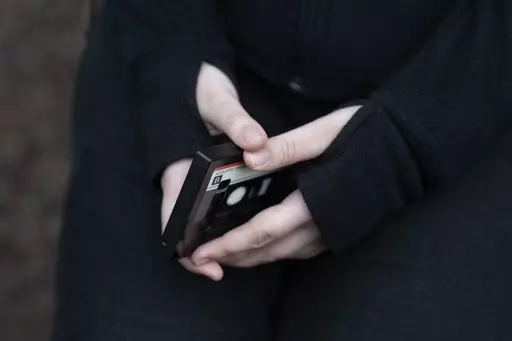 A teenager holds her phone as she sits for a portrait near her home in Illinois, on Friday, March 24, 2023. The U.S. Surgeon General is warning there is not enough evidence to show that social media is safe for young people — and is calling on tech companies, parents and caregivers to take "immediate action to protect kids now." (AP Photo Erin Hooley, File)