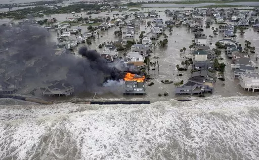Fire destroys homes along the beach on Galveston Island, Texas, as Hurricane Ike approaches, Sept. 12, 2008. Hurricanes beginning with the letter "I" have been among the most destructive to strike the United States, moreso than any other letter of the alphabet. Idalia is on a path to strike Florida's Gulf Coast as a major hurricane to join the long list of catastrophic examples. (AP Photo/David J. Phillip, File)