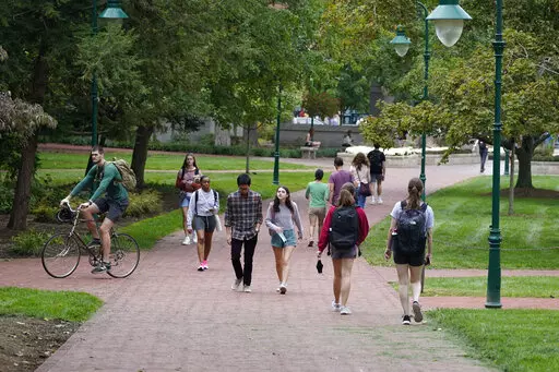 Students walk to and from classes on the Indiana University campus, Thursday, Oct. 14, 2021, in Bloomington, Ind. Between fall 2019 and 2021, college enrollment nationwide fell by nearly a million students — and for a number of financial reasons, this fall is an ideal time for students to resume their education to attain a degree or credential. The advantage of earning a degree is still evident since higher education typically results in bigger lifetime earnings and postponing your education m