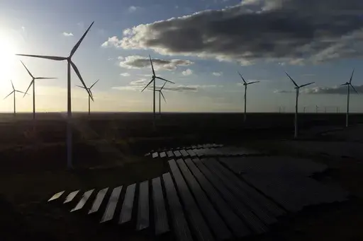Wind turbines spin at the Klettwitz Nord solar energy park near Klettwitz, Germany, Oct. 15, 2024. (AP Photo/Matthias Schrader, File)