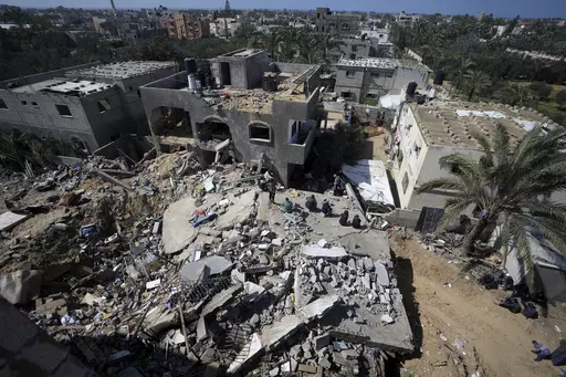 Palestinians look at destruction after an Israeli airstrike on a residential building of the Ganan family in Deir al Balah, Gaza Strip, Thursday, March 7, 2024. (AP Photo/Adel Hana)
