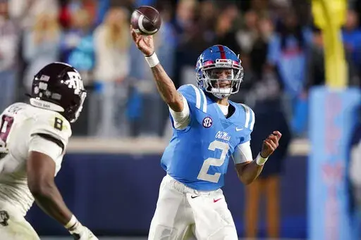 Mississippi quarterback Matt Corral throws a pass as Texas A&M defensive lineman DeMarvin Leal (8) defends during the second half of an NCAA college football game, Saturday, Nov. 13, 2021, in Oxford, Miss. (AP Photo/Rogelio V. Solis)