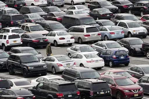 A person walks through a parking lot at a shopping mall on Dec. 8, 2016 in King of Prussia, Pa. Many newer cars use wireless key fobs and push-button starters. The technology makes it more convenient to get into your vehicle, but it also makes things easier for thieves. (AP Photo/Matt Rourke, File)