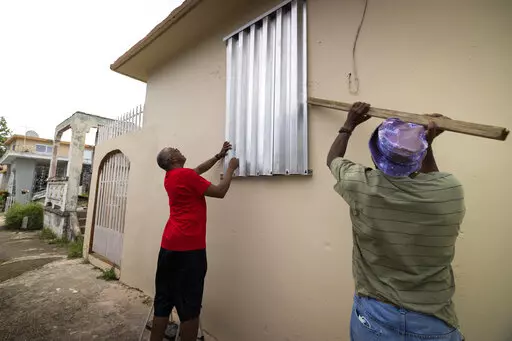 Residents prepare for the arrival of Tropical Storm Fiona, in Loiza, Puerto Rico, Saturday, Sept. 17, 2022. Fiona was expected to become a hurricane as it neared Puerto Rico on Saturday, threatening to dump up to 20 inches (51 centimeters) of rain as people braced for potential landslides, severe flooding and power outages. (AP Photo/Alejandro Granadillo)