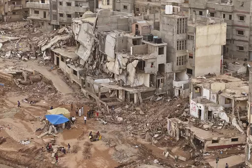 Rescuers and relatives of victims set up tents in front of collapsed buildings in Derna, Libya, Monday, Sept. 18, 2023. Some 11,300 people died when two dams collapsed during Mediterranean storm Daniel last week sending a wall of water gushing through the city, according to the Red Crescent aid group. A further 10,000 people are missing, and presumed dead. (AP Photo/Muhammad J. Elalwany)