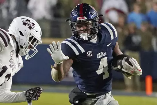Mississippi running back Quinshon Judkins (4) looks to fend off Mississippi State safety Shawn Preston Jr. (12) during the second half of an NCAA college football game in Oxford, Miss., Thursday, Nov. 24, 2022. Judkins set the Rebels' single-season rushing record and led the SEC with 1,567 yards and 16 touchdowns as a freshman. (AP Photo/Rogelio V. Solis, File)