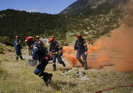Firefighters of the 1st Wildfire Special Operation Unit, take part in a drill near Villia village some 60 kilometers (37 miles) northwest of Athens, Greece, Friday, April 19, 2024. Greece's fire season officially starts on May 1 but dozens of fires have already been put out over the past month after temperatures began hitting 30 degrees Celsius (86 degrees Fahrenheit) in late March. This year, Greece is doubling the number of firefighters in specialized units to some 1,300, adopting tactics from