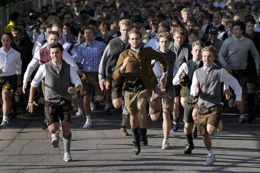 People run to enter the 188th 'Oktoberfest' beer festival in Munich, Germany, Saturday, Sept. 16, 2023. (AP Photo/Matthias Schrader)